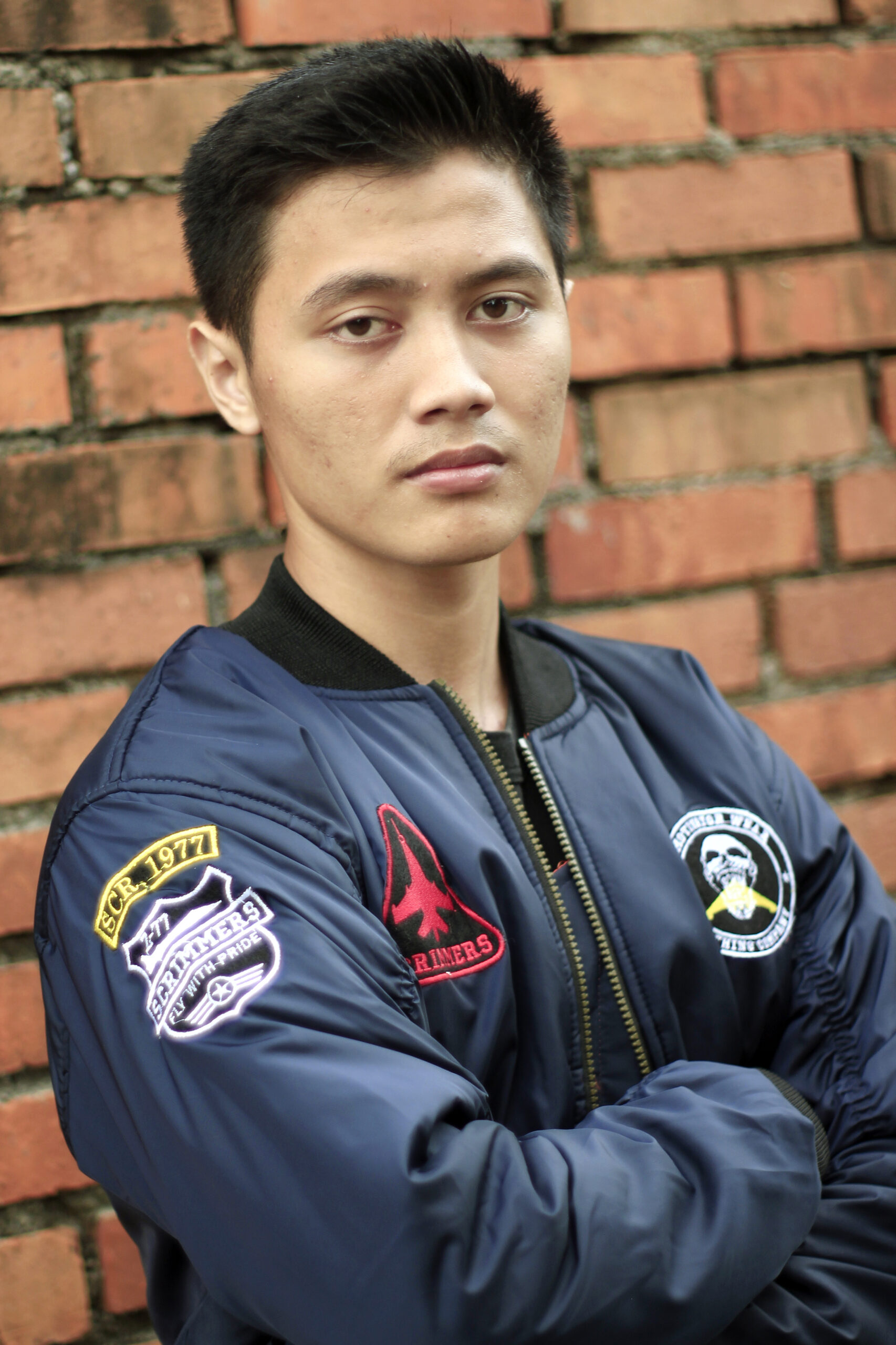 Navy Bomber Jacket with Embroidery Man wearing a navy bomber jacket with embroidered patches